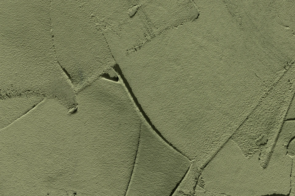 Espace de travail d'architecte ou designer d'intérieur avec plans techniques détaillés, nuancier de couleurs déployé, échantillons de matériaux bois, pinceau professionnel et pot de peinture ouverte