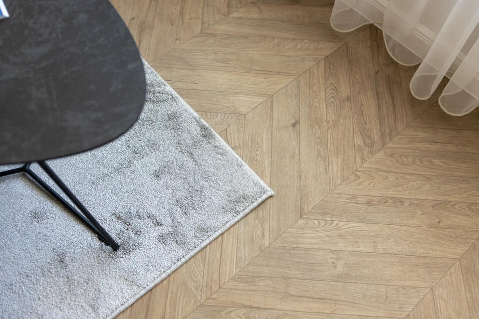 Intérieur résidentiel présentant un sol en parquet massif chêne disposé en motif chevron ou point de Hongrie